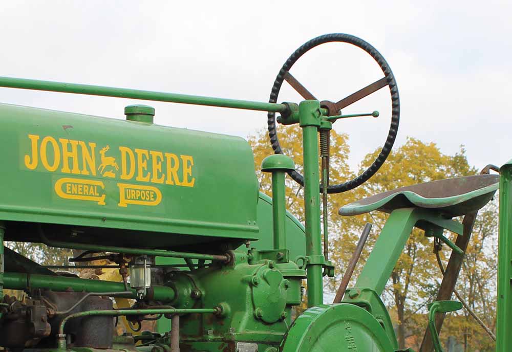 Part of a green John Deere tractor outside