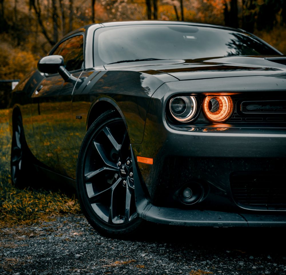 Dodge Challenger parked outside with headlights on