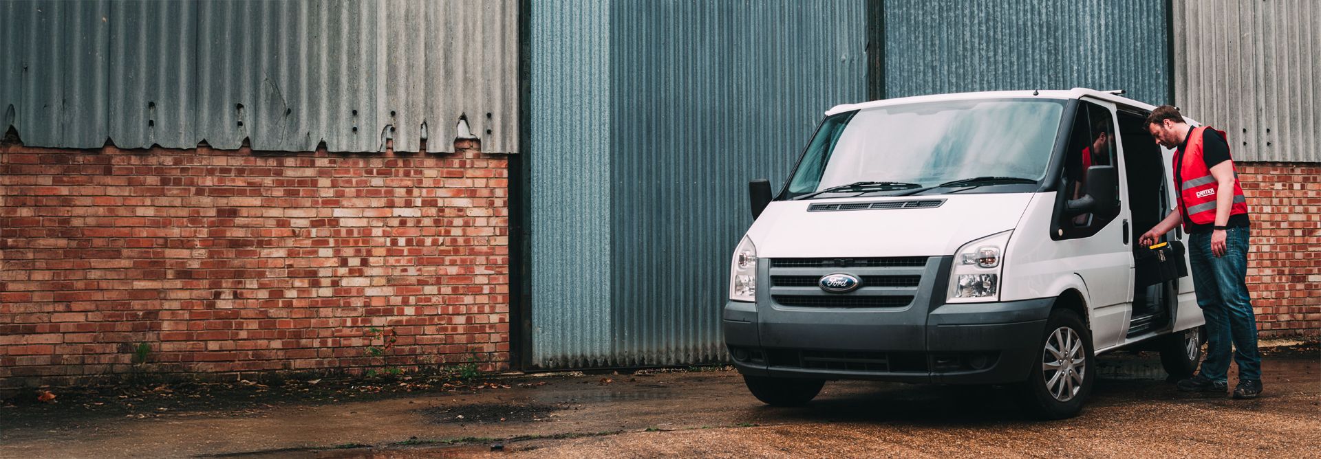 Builder leaning into a van to take out his tool box