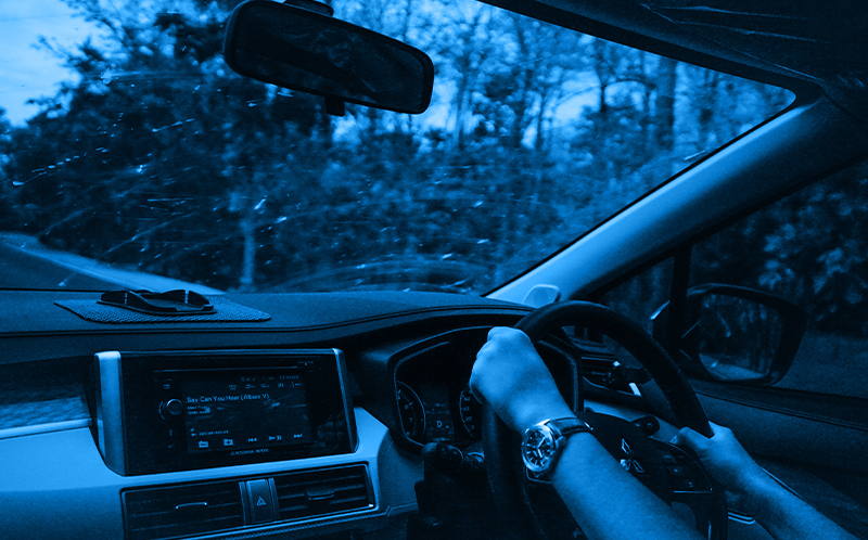 Person driving a car, blue filter on the image