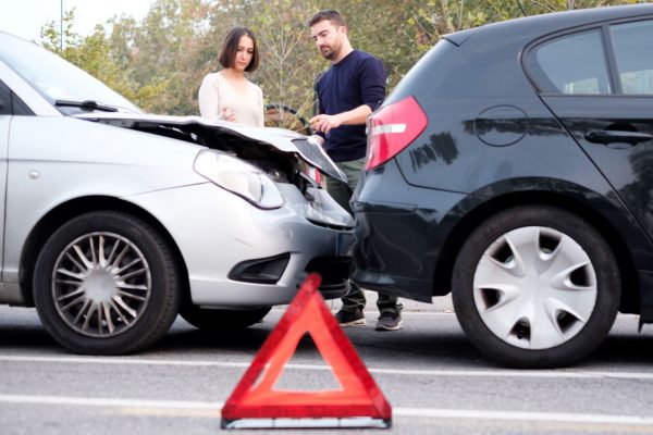 Two people exchanging insurance information after an accident