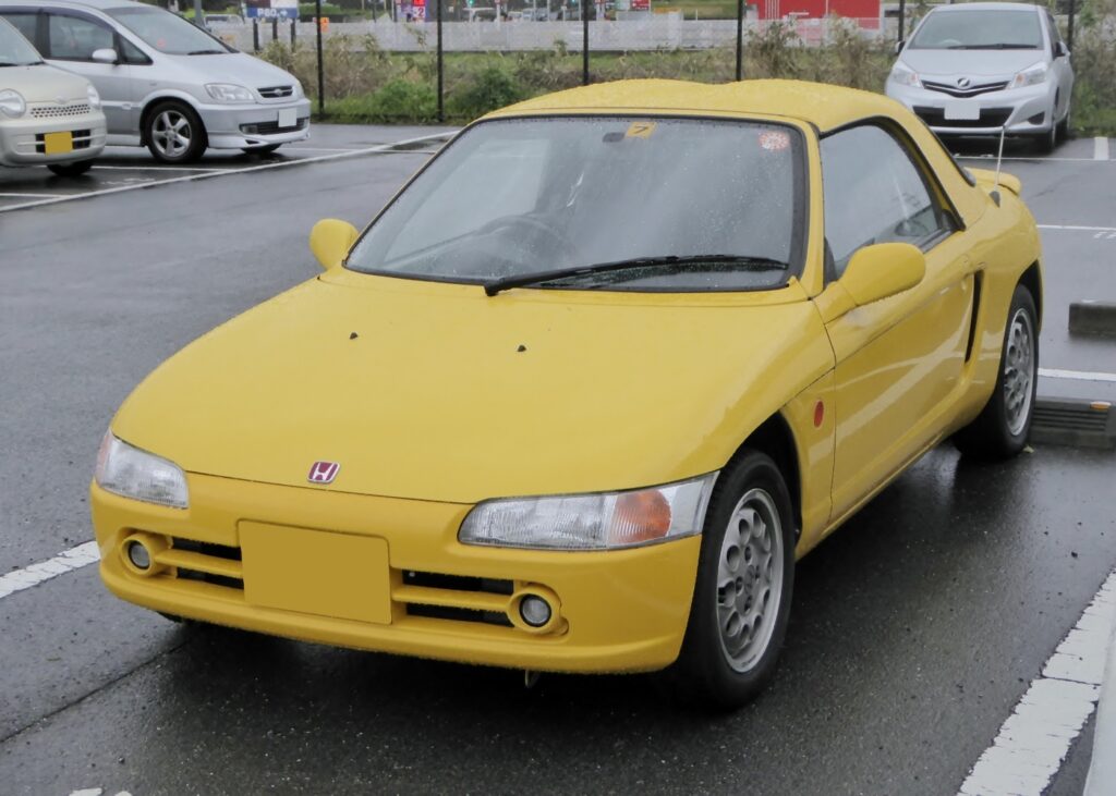Yellow Honda beat parked in a carpark