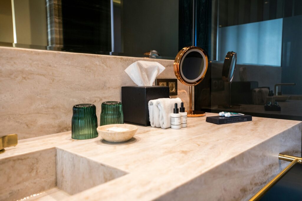 Elegant bathroom with guest toiletries and mirror on sink countertop 