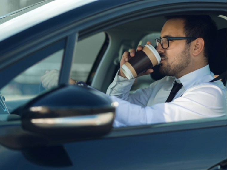 Man sipping on a coffee while driving