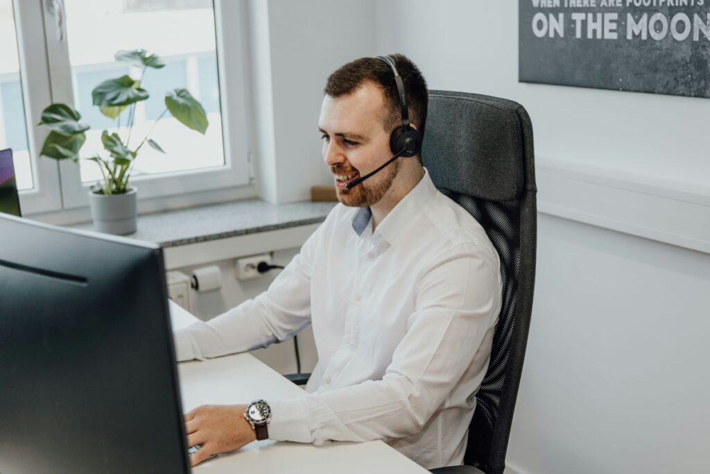 Man wearing a headset sitting in front of a computer