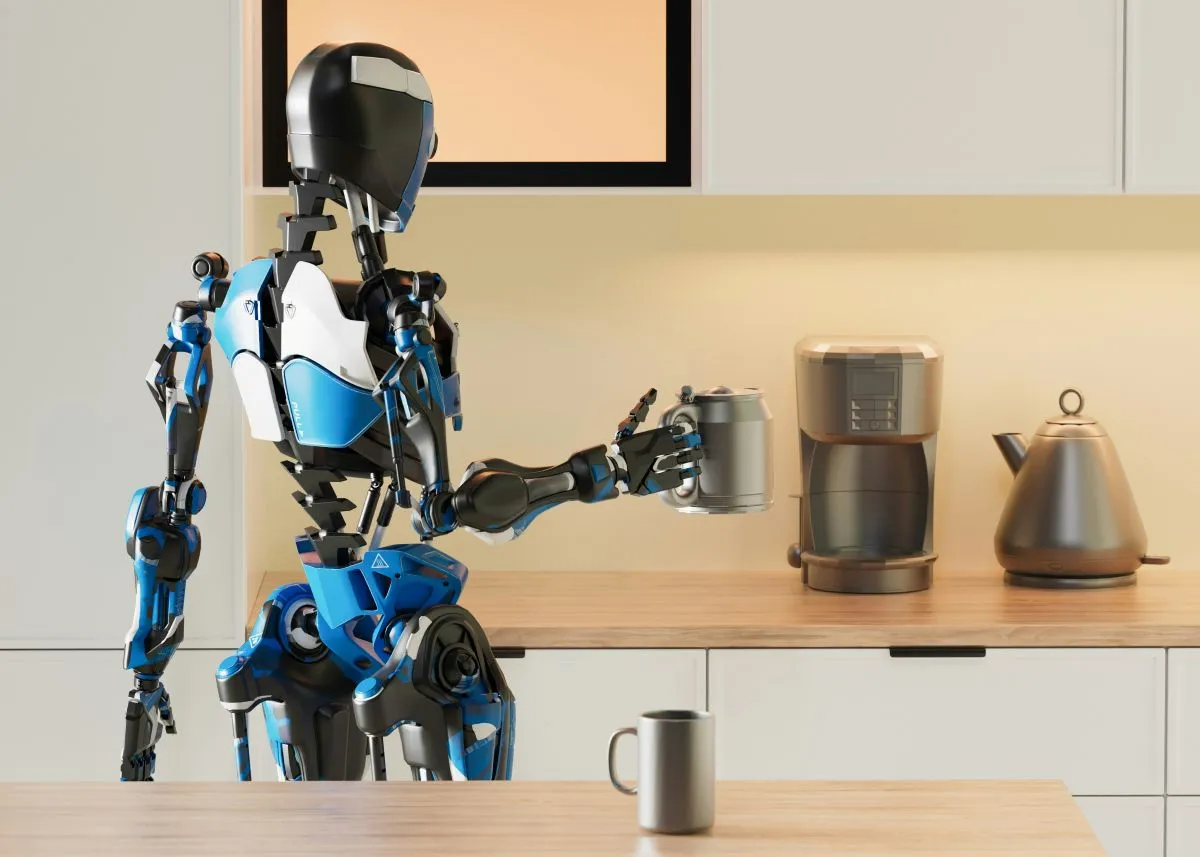A humanoid robot in a kitchen holds a mug near a coffee maker and a kettle on a wooden worktop. The setting is modern and well-lit.