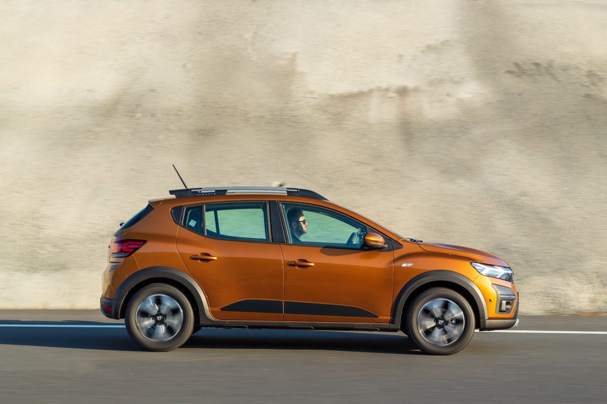 Orange Dacia Sandero driving on the road