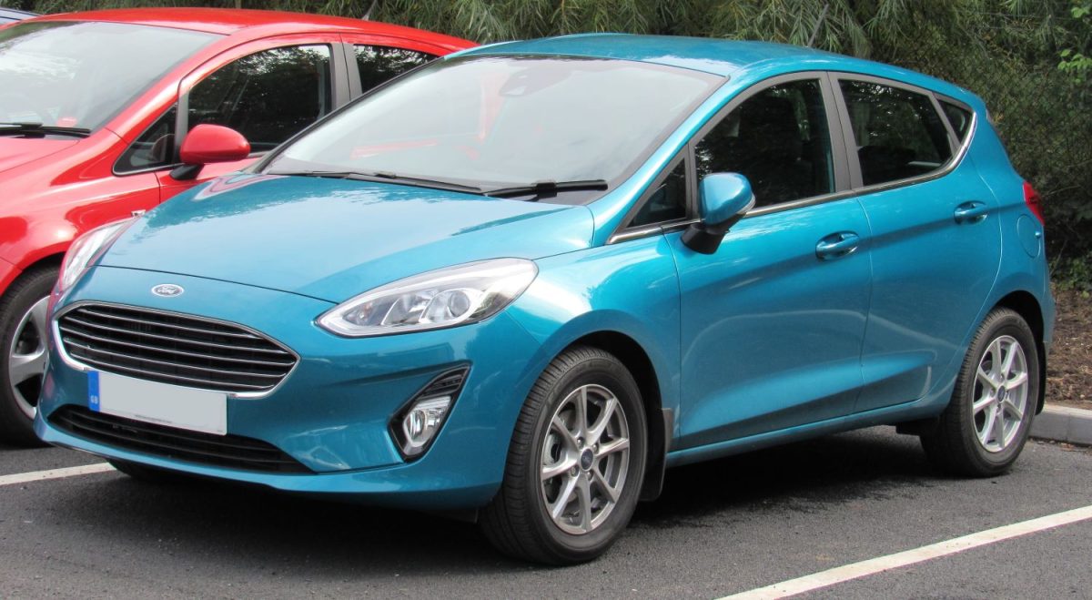 Blue Ford Fiesta parked outside next to a red car